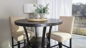 Een ronde tafel met twee fauteuils, een potplant en een decoratief dienblad.