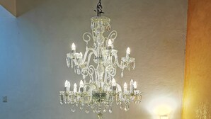 Ein prächtiger Kronleuchter hängt von der Decke in einem geräumigen Zimmer mit einer modernen Treppe.