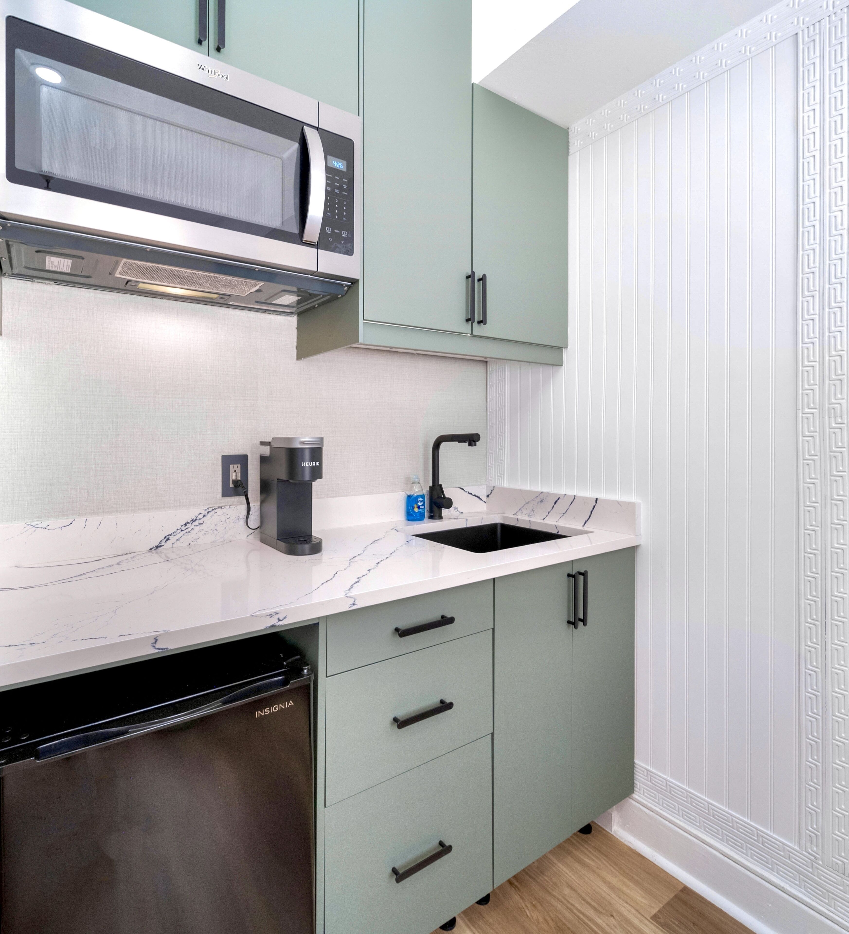 Una cocina equipada con microondas, cafetera y lavaplatos.