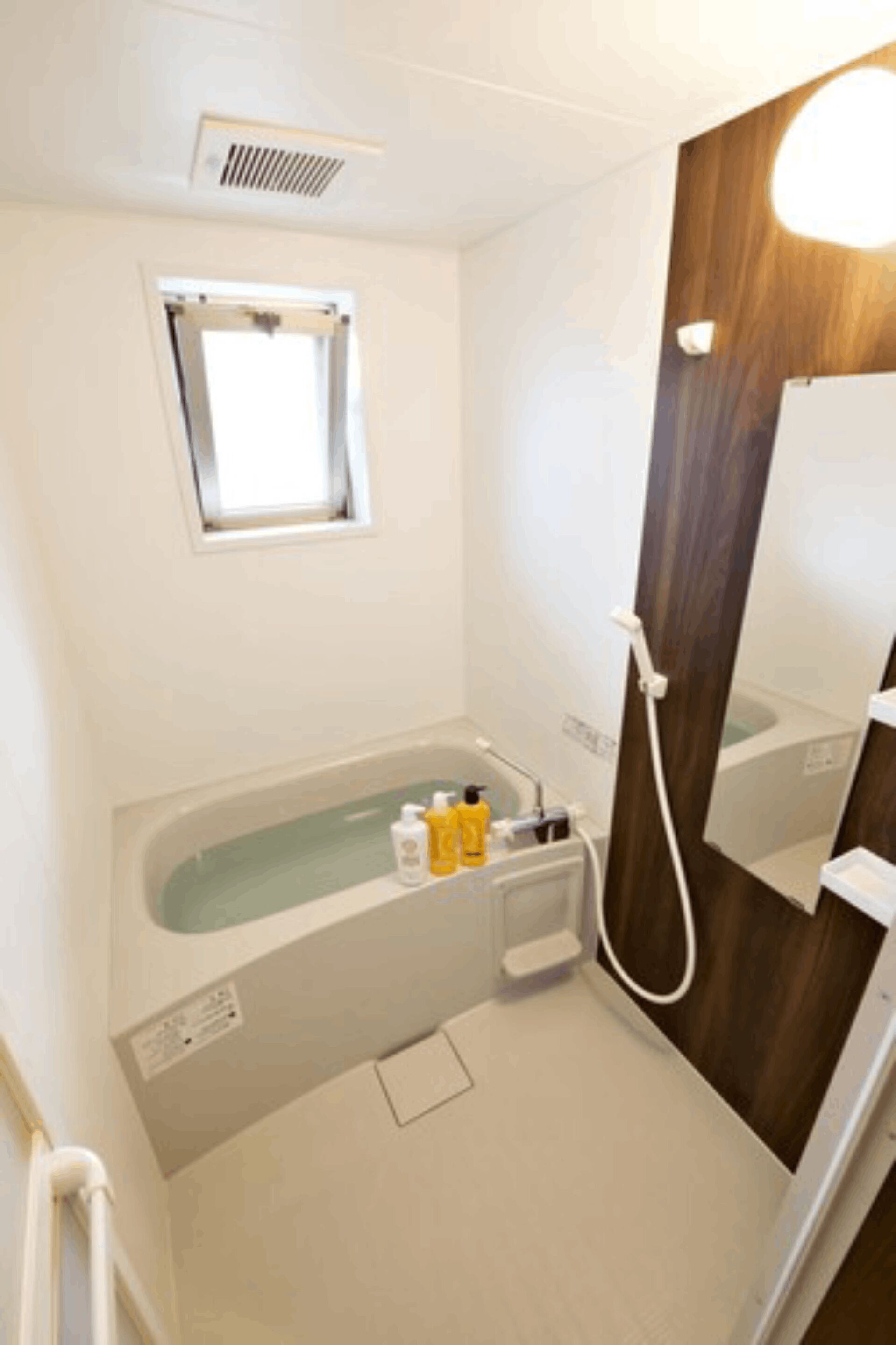 Une salle de bain avec une baignoire, une fenêtre et un miroir.