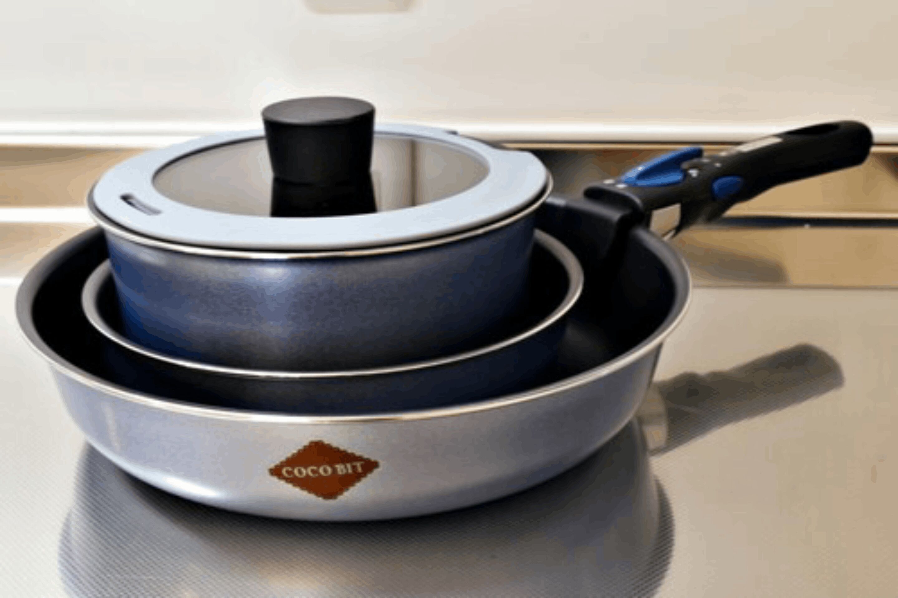 A kitchen with a stove, a pot, and a pan.