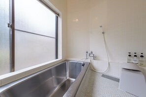 Un baño con un ventanal amplio, una bañera y una ducha.