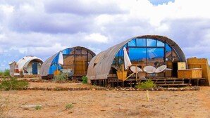Une série de cabines en forme de dôme, dotées de grandes fenêtres, de terrasses en bois et d’espaces de détente en plein air.