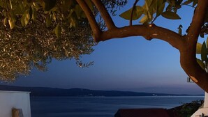 An outdoor swimming pool with a view of the sea at dusk. - Luxury apt w shared pool,3 balconies and terrace (Omis)