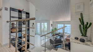 A modern interior with a staircase, a living area with a sofa and coffee table, and a cactus plant. - Luxury apt w shared pool,3 balconies and terrace (Omis)