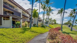 A multi-story hotel with balconies, surrounded by palm trees and a golf course. - 2 Story top level AC unit 2 bdrms w/Large Loft with 2 twin beds & bathrm SUNSETS (Kailua-Kona)