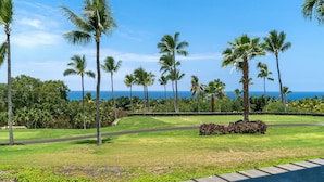 A tropical landscape with palm trees and a view of the ocean. - 2 Story top level AC unit 2 bdrms w/Large Loft with 2 twin beds & bathrm SUNSETS (Kailua-Kona)