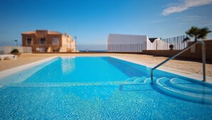 A swimming pool with a clear view of the sea and buildings in the background. - Vacation Apartment Arenas del Porís with Sea View and Shared Pool (Arico)