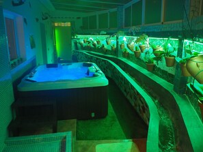 A spa area with a hot tub and a row of potted plants.