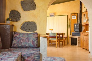 A cozy interior with a sofa, a dining table, and a kitchen area. - Finca "La Acequia" with Whirlpool, Fast Wi-Fi, Terrace & Garden (Valleseco)