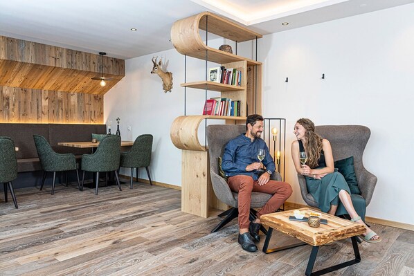 Un intérieur moderne avec une bibliothèque en bois, un coin salon et un espace repas.