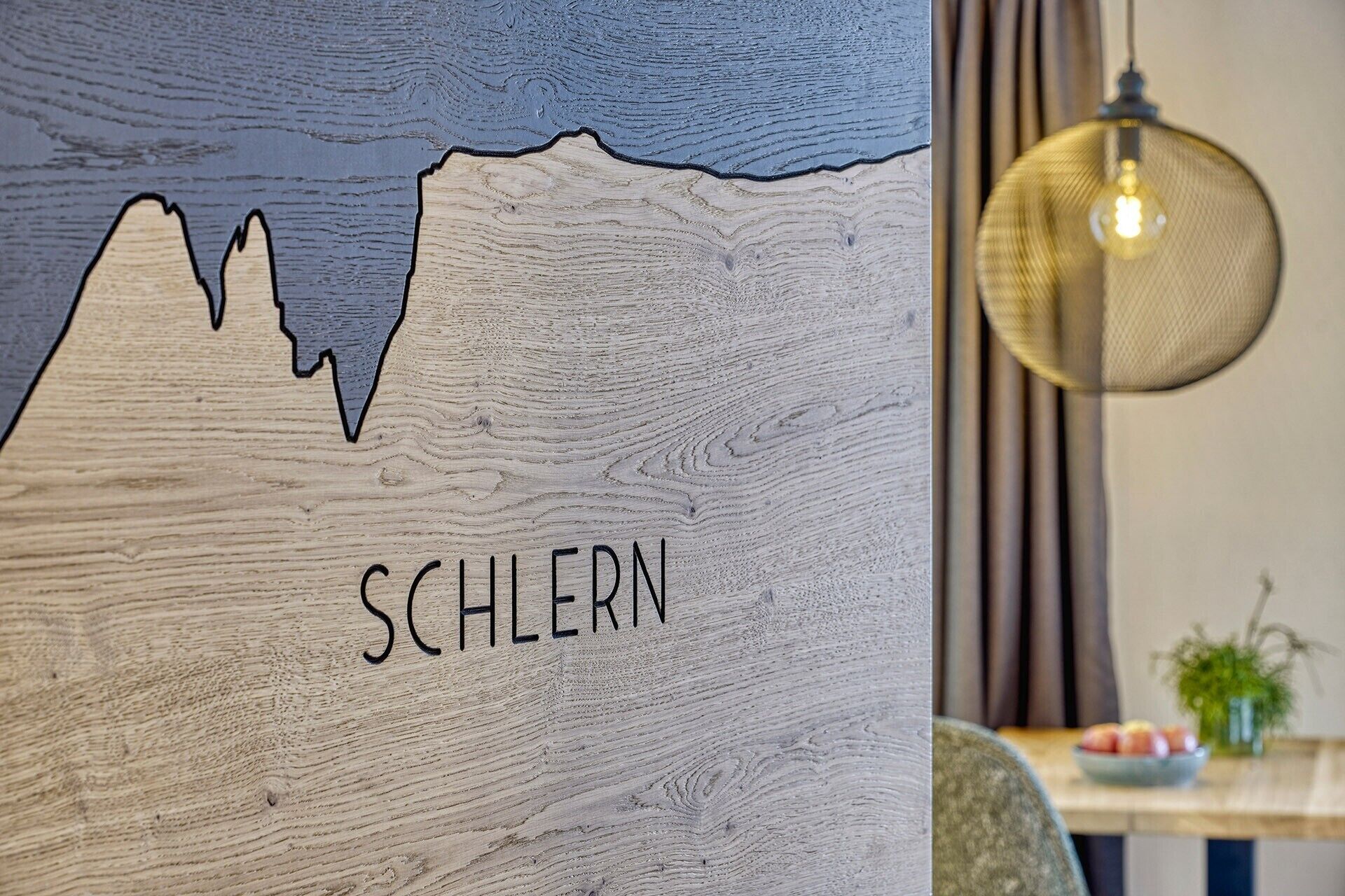 A wooden wall with a mountain silhouette and the word 'SCHLERN' on it.