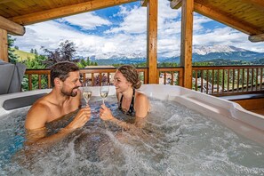 Un couple dans un jacuzzi avec vue sur la montagne.