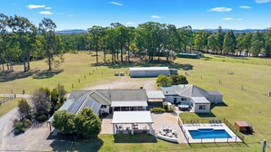 Una propiedad residencial con piscina, paneles solares y patio cercado.