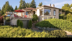 Una casa moderna con balcón, piscina y jardín bien cuidado.