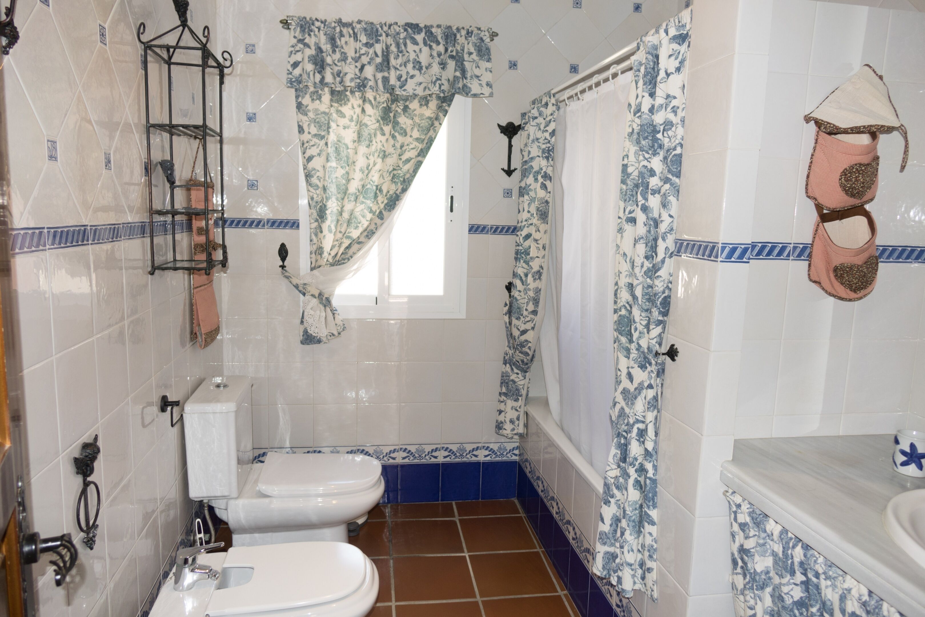 Un baño con dos inodoros, un lavamanos y una bañera.