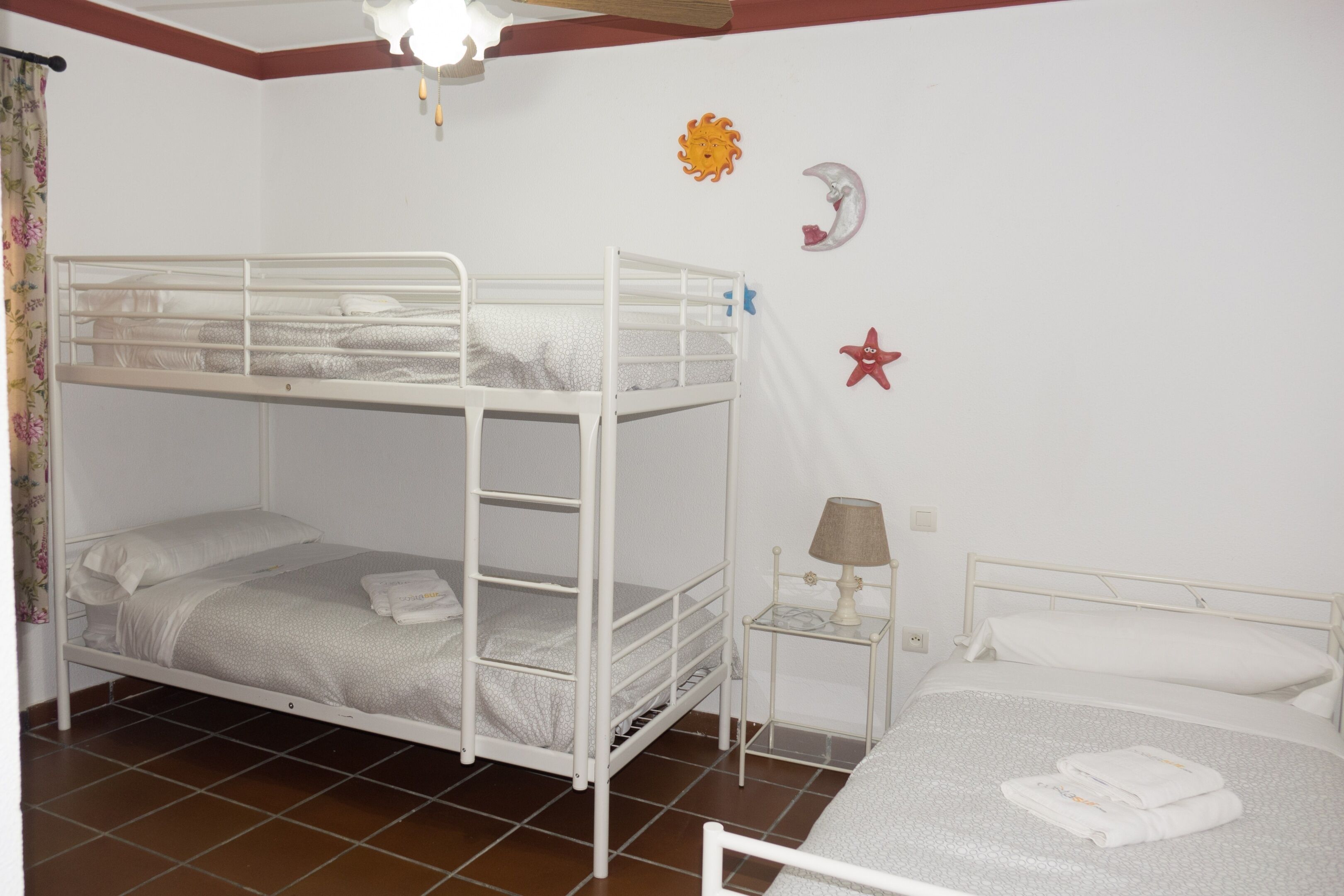 A bunk bed room with a small table and a lamp.