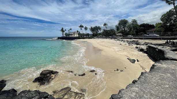 A beach with clear turquoise water, sandy shores, and rocky outcrops. - Kona coast Ali'i Dr location by ocean, free, PKG WIFI salt water pool Poke shack (Kailua-Kona)