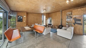 Un interior modern amb un sostre de fusta, una llar de foc i una estanteria amb el lema 'Platja'.
