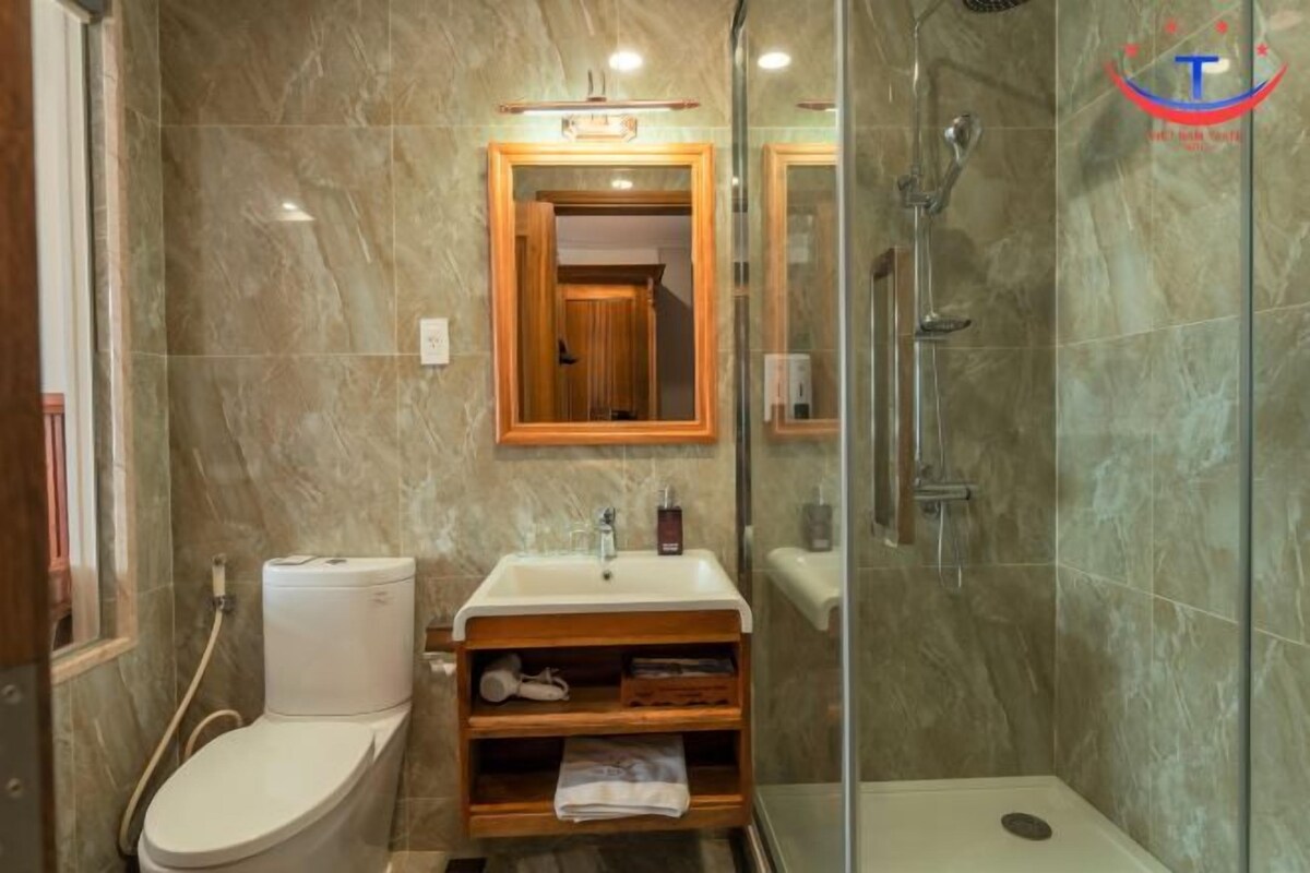 A bathroom with a toilet, sink, and shower.