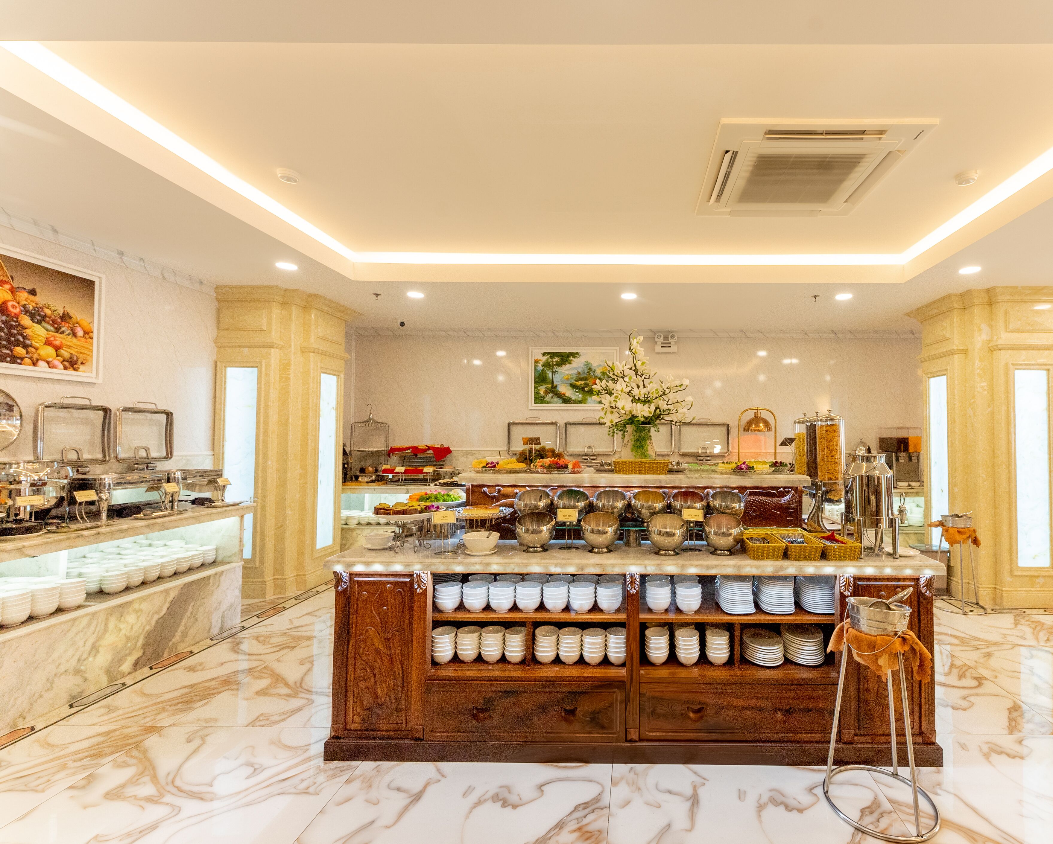 A buffet setup with multiple serving stations, a marble floor, and a decorative centerpiece.