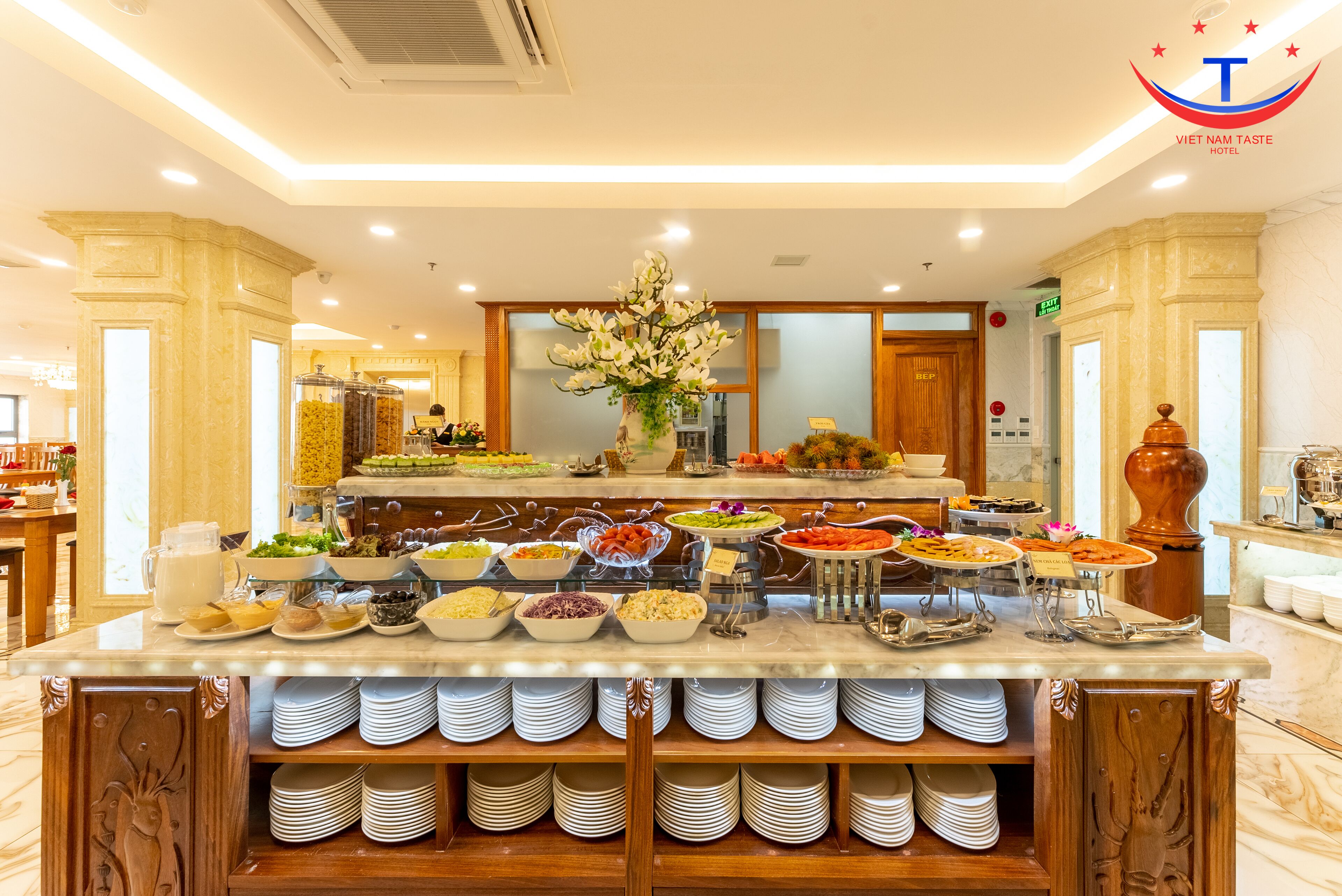 A buffet setup with various food items and a floral centerpiece.