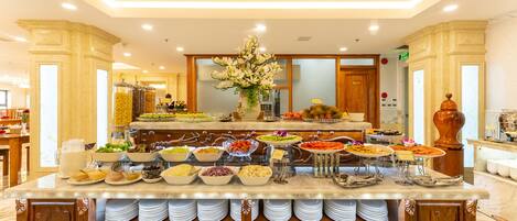 A buffet setup with various food items and a floral centerpiece.