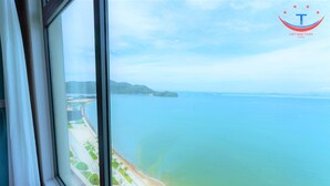 A view from a hotel room with a large window overlooking a beach and the sea. - Vietnam Taste Hotel Quy Nhon - Beachfront (Quy Nhon)