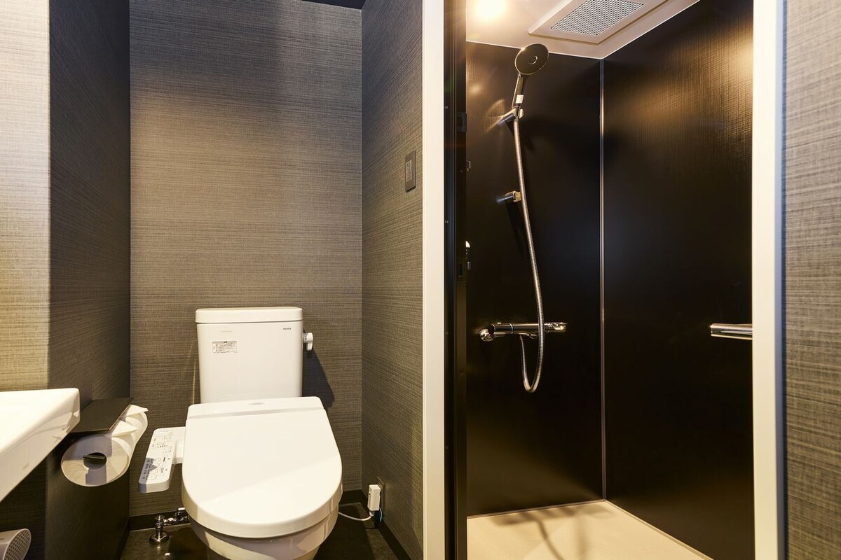 Une salle de bain moderne équipée de toilettes, d’un bidet et d’une douche.