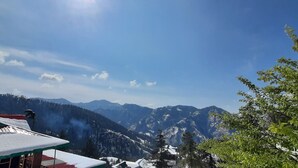 A mountainous landscape with snow-covered peaks and a clear sky. - Newly built bnb in a pristine village (Shimla)