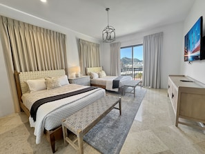 Relax in a spacious room with a large bed, two smaller beds, and a comfortable bench.