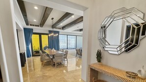 Un interior moderno con comedor, un espejo grande y una consola.