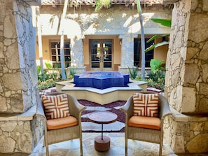 Relax in a serene outdoor setting with a hot tub and comfortable seating area.