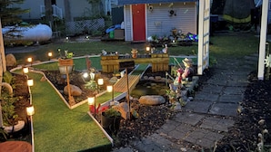 A garden with a pond, stepping stones, and a wooden deck. - 
Large Lakehouse w Private Beach~Hot Tub~Tiki Hut~Game Rm~Gym~Mini-Golf~Dogs OK! (Grand Junction)