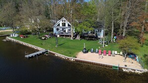 A lakeside cabin with a dock, a grassy deck, and outdoor seating. - 
Large Lakehouse w Private Beach~Hot Tub~Tiki Hut~Game Rm~Gym~Mini-Golf~Dogs OK! (Grand Junction)
