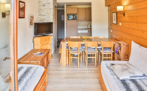 Un espacio habitable compacto con kitchenette, comedor y cama.