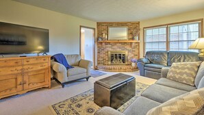 Una sala de estar con chimenea, televisor, sofá y mesa de centro.