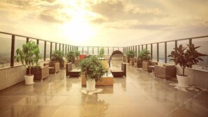 A rooftop terrace with potted plants, seating areas, and a view of the cityscape. - Atour Hotel (Hangzhou)