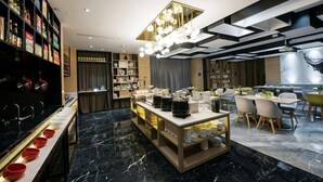 A modern hotel lobby with a marble floor, a central serving area, and a dining area with chairs and tables. - Atour Hotel (Hangzhou)