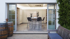 An open-plan kitchen with a dining area, featuring a table and chairs, a bench, and a potted plant. - Exclusive Cortijo surrounded by an olive grove (Arcos de la Frontera)