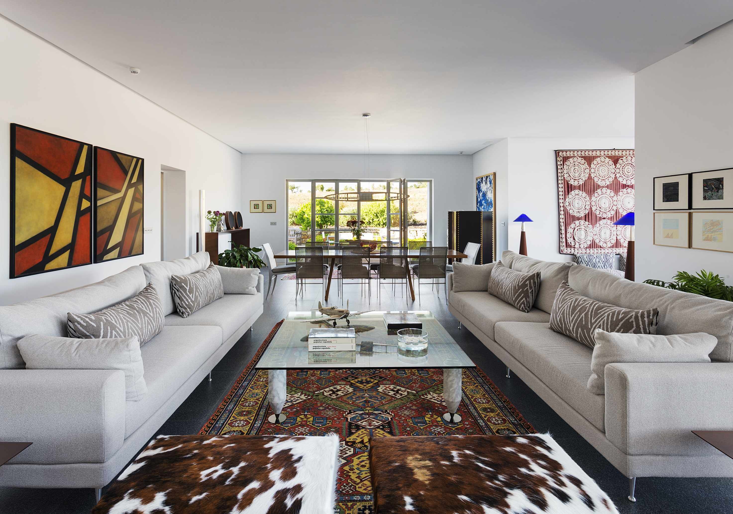A modern living room with two sofas, a coffee table, and a patterned rug.
