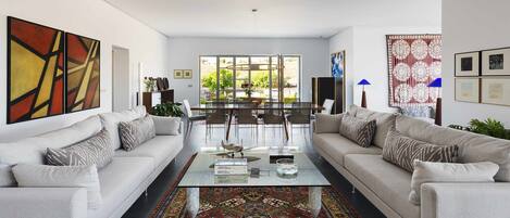 A modern living room with two sofas, a coffee table, and a patterned rug.