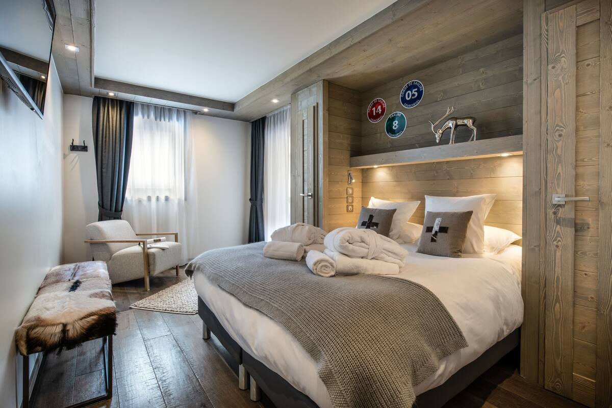 Ein modernes Schlafzimmer mit einem großen Bett, einem Holz-Kopfteil, einem Schreibtisch und einem Stuhl.