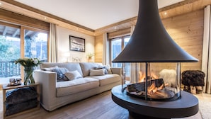 Een gezellige woonkamer met een moderne haard, een comfortabele bank en een houten vloer.
