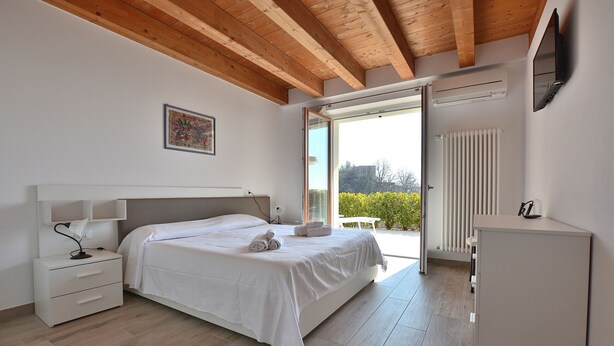 Ein Schlafzimmer mit Bett, Nachttisch und kleinem Schrank.