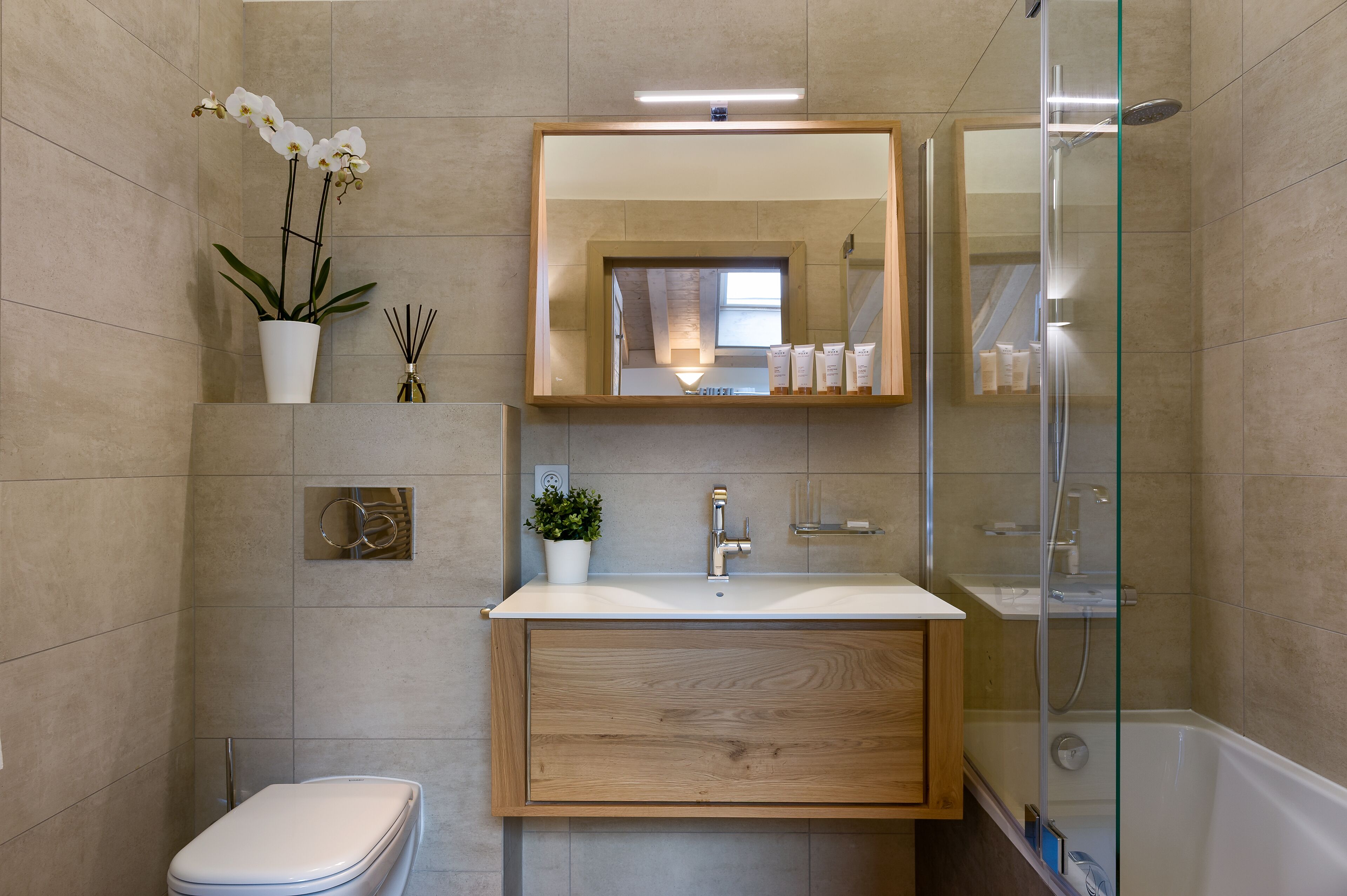 Une salle de bain moderne équipée de toilettes, d’un lavabo et d’une douche.