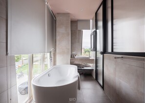 A modern bathroom with a freestanding bathtub, a large window, and a view of the outside. - Star Deco Resort (Dongshan)