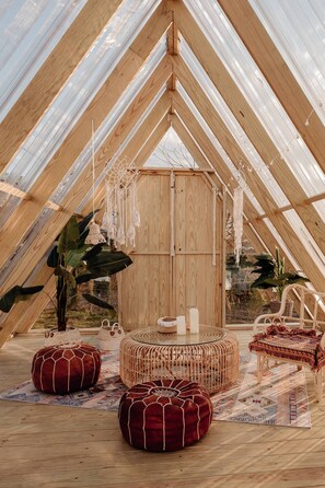 A cozy, wooden interior with a round table, red poufs, and hanging dreamcatchers. - Star Deco Resort (Dongshan)