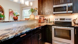 Una cocina moderna con armarios de madera oscura, electrodomésticos de acero inoxidable y encimera de granito.