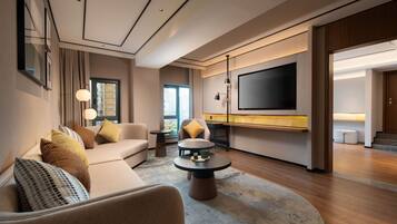 Suite Deluxe, 1 très grand lit | Coin séjour | Télévision à écran plat de 65 pouces avec chaînes par câble